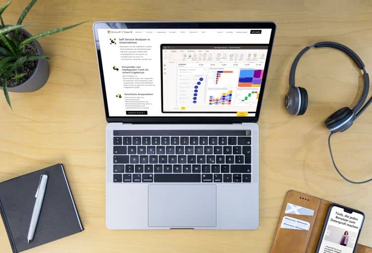 Nutzen Sie Power Pivot für Ihr Reporting Laptop mit Power BI auf Schreibtisch mit Smartphone, Pflanze, Kopfhörern
