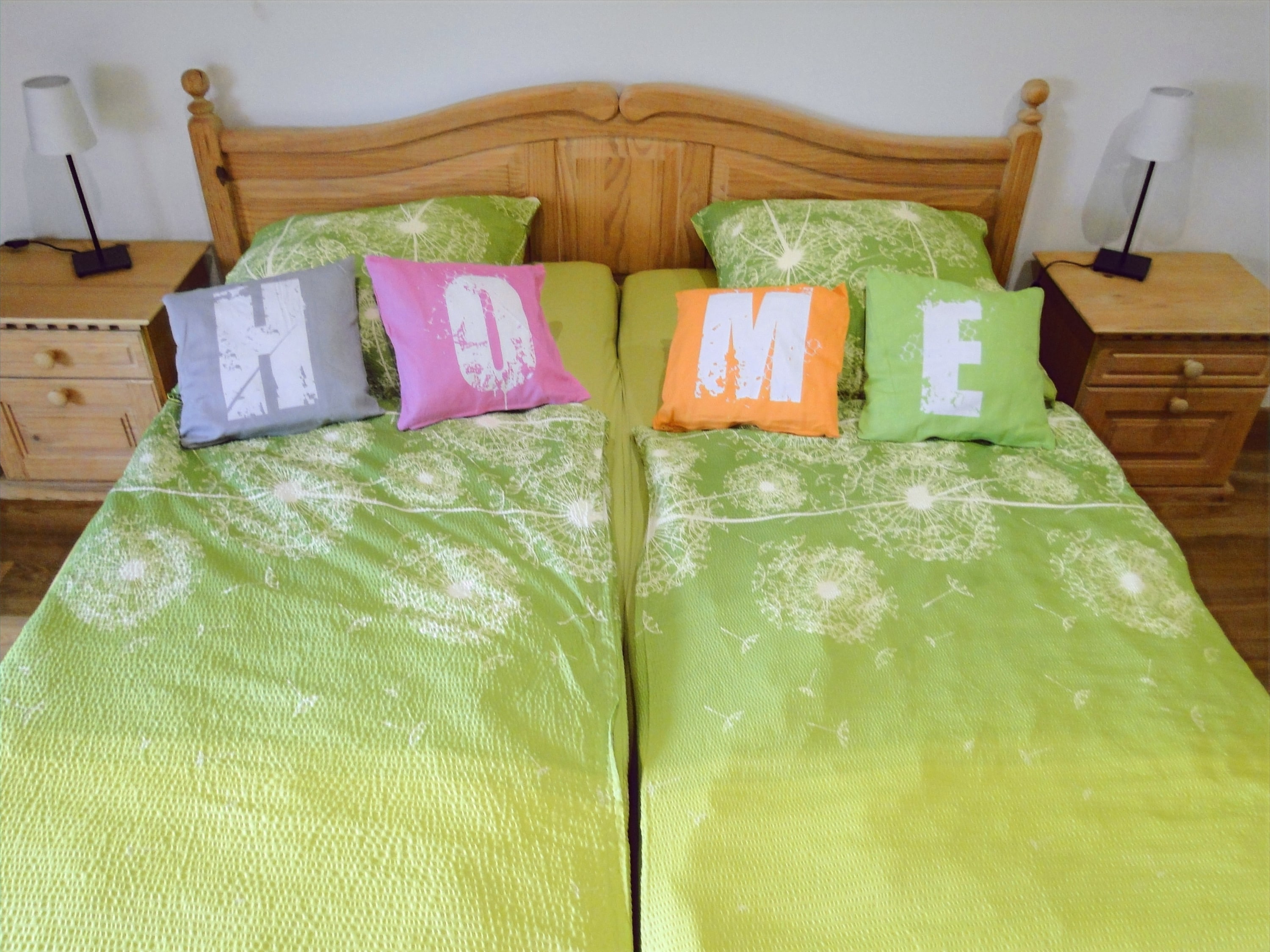 Doppelbett mit Buchstabenkissen, die das Wort "HOME" bilden