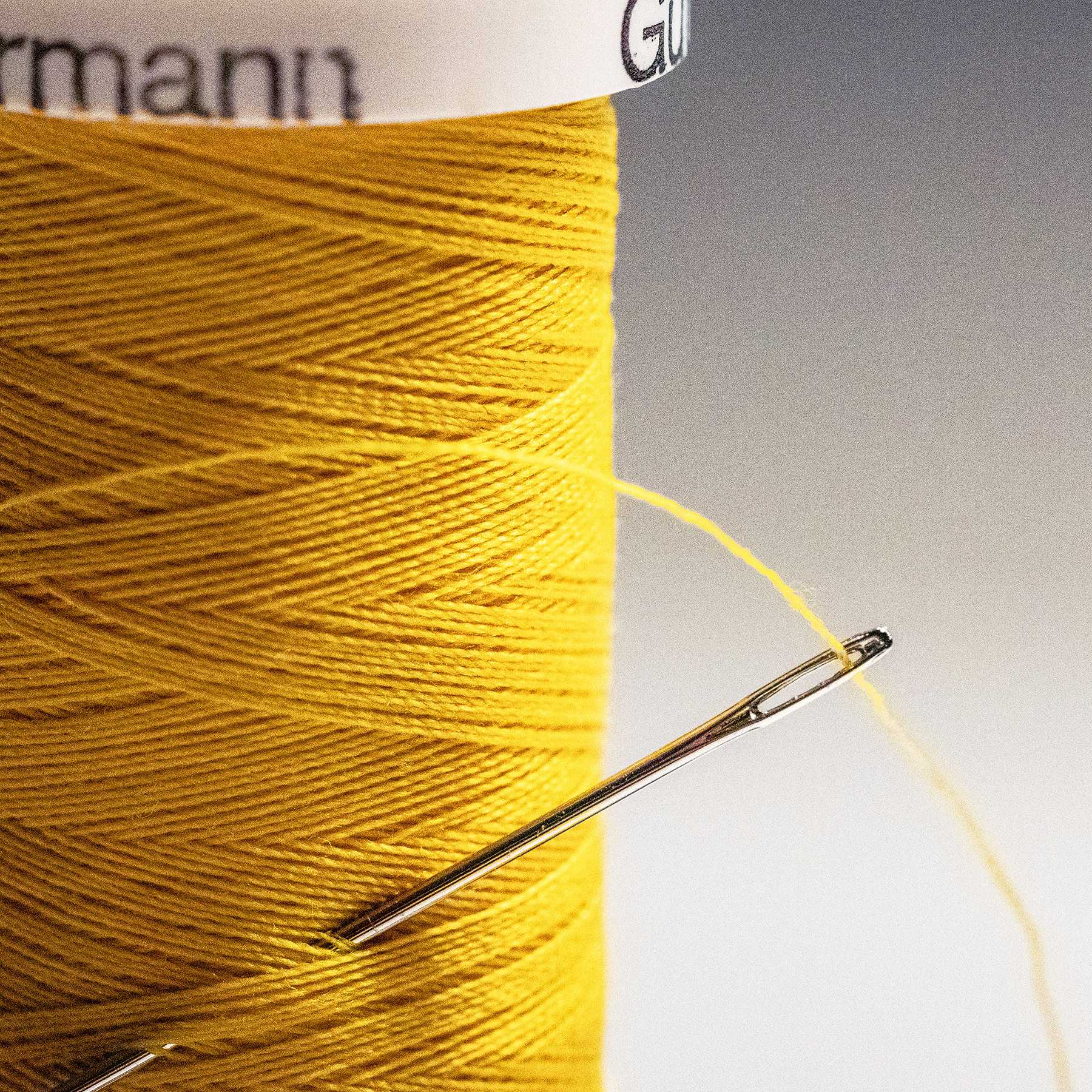 close-up of yellow thread and needle