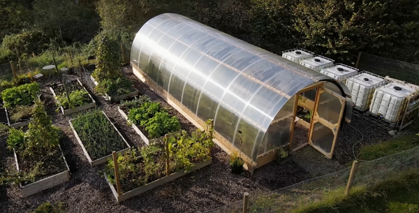 An aerial view of a garden with beds and a polytunnel