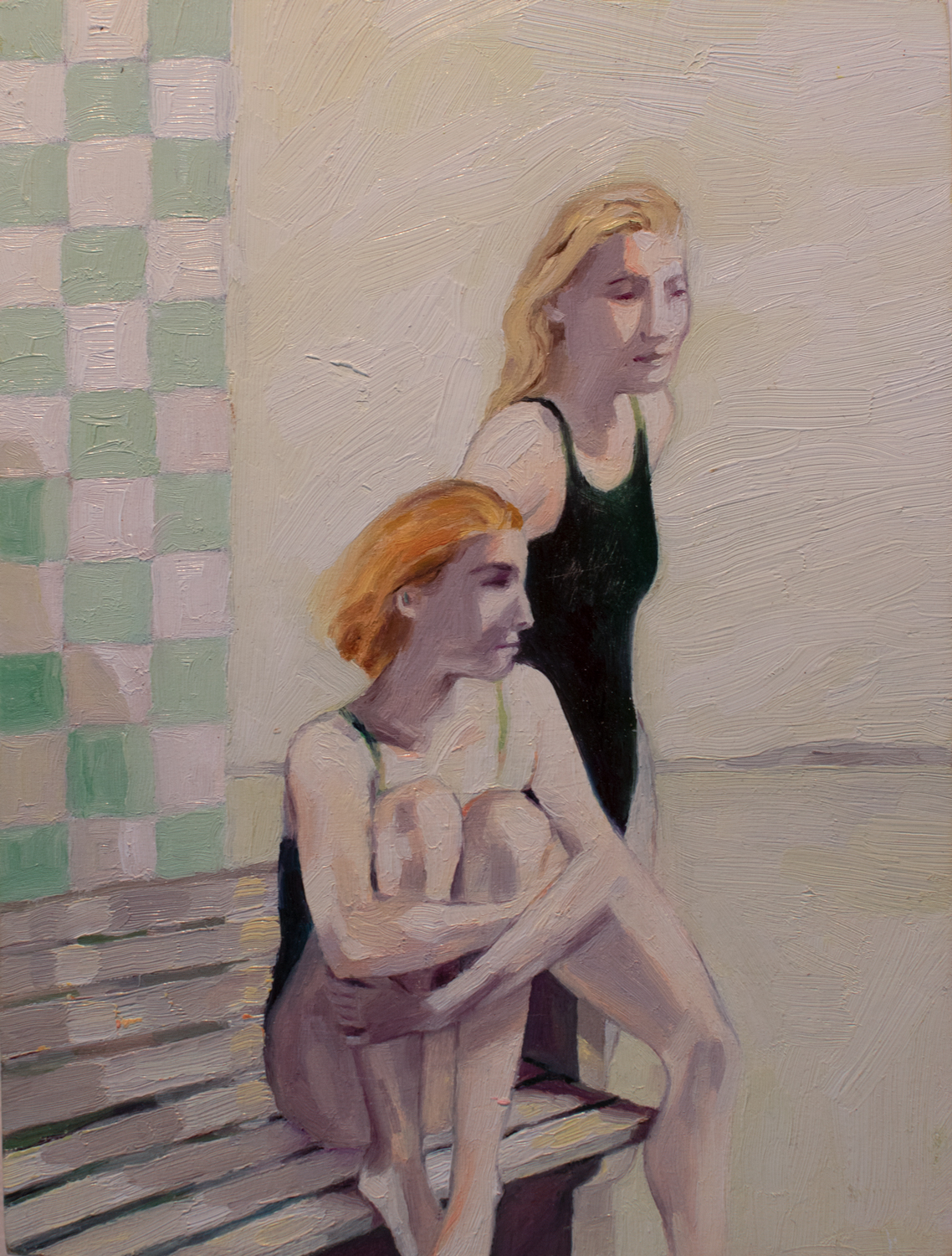 Two young women sitting on a bench. They have recently gotten out of the water. wistful