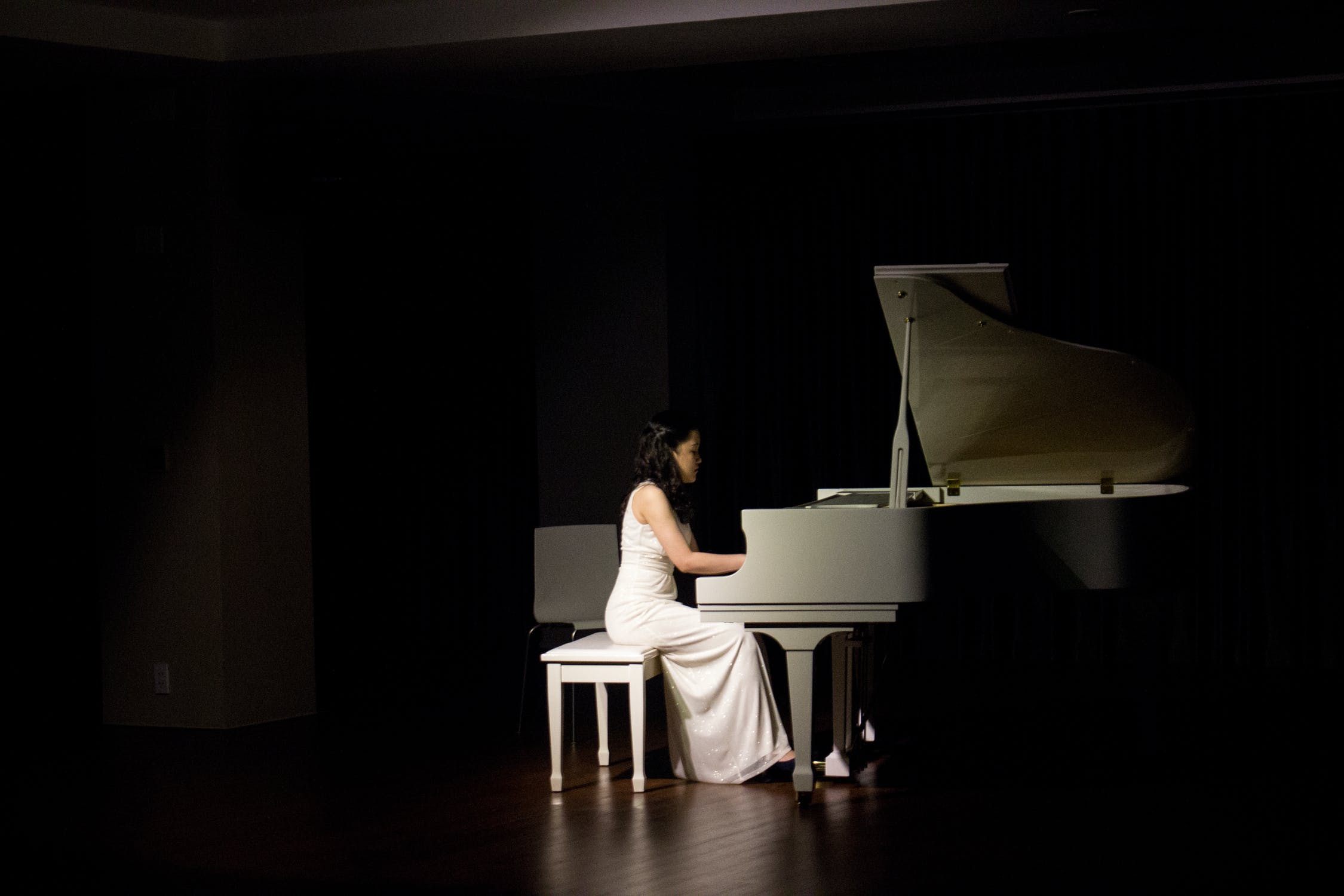 lady in a dark setting playing piano
