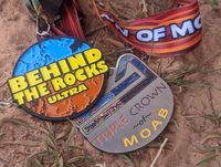 Finisher medals for the the Moab Behind the Rocks 50k race and Moab Triple Crown