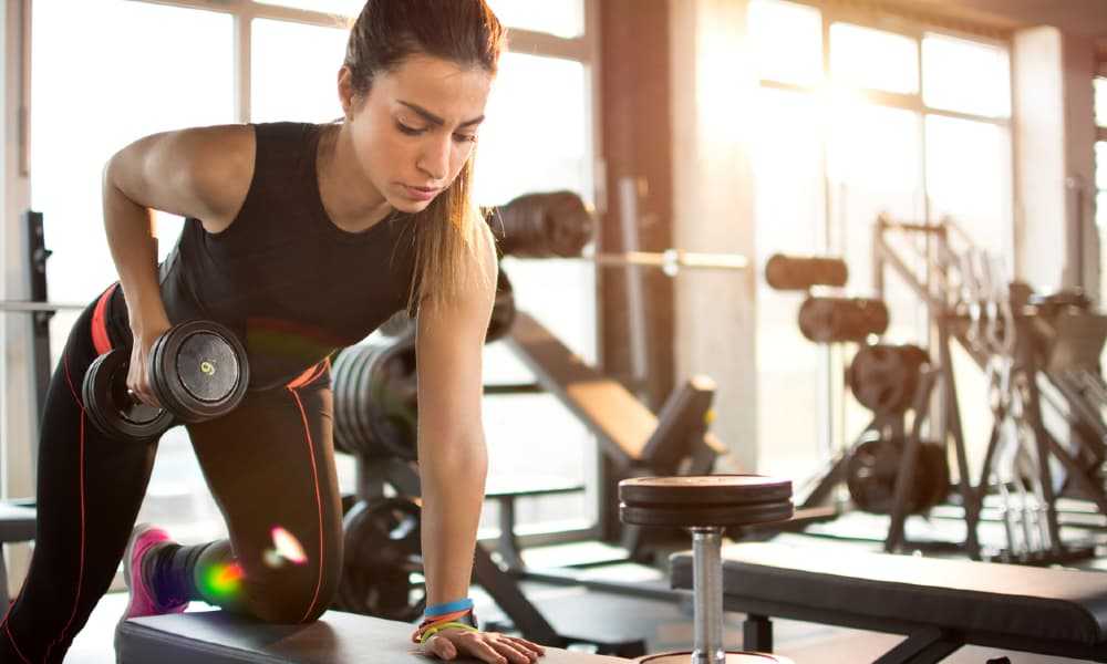 Fit woman lifting dumbbell in the morning.