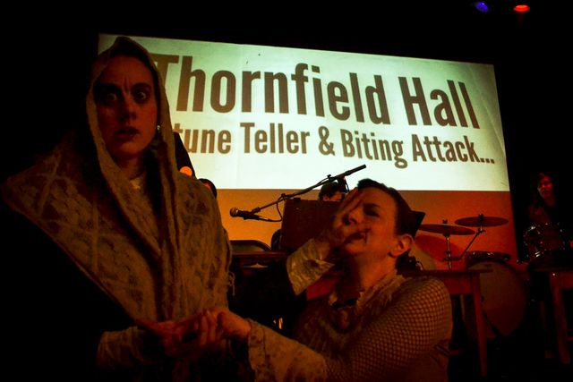 Mr Rochester disguised as a fortune teller,
with her hand on Jane's face.
Behind them, the projection says
Thornfield Hall, fortune teller & biting attack.
