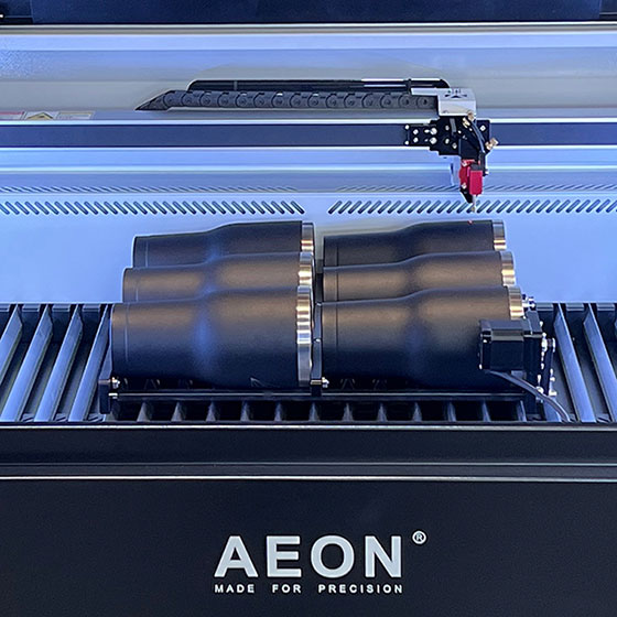 six tumblers sitting in the Multi-Roller device inside an Aeon laser machine
