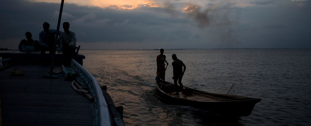 Two boats travel across the Haor floodplains of northeast Bangladesh