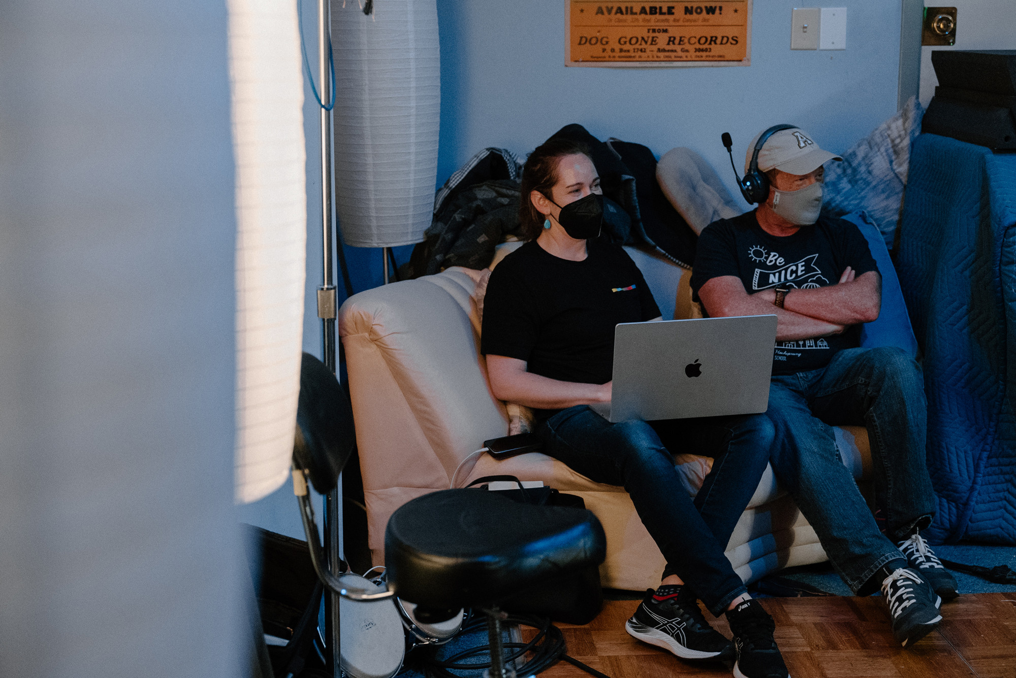 Two members of the production team sitting side-by-side on a couch.