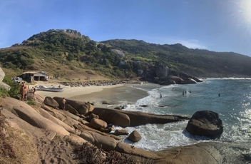 Vista panoramica da pequena praia do gravatá feita de cima das pedras características do local ao fundo o céu azul com o sol brilhante