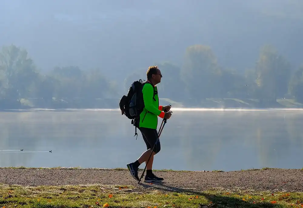 Man Nordic walking by a lake