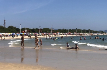 Praia da Daniela pegando toda curva da praia, banhistas e mar a direita