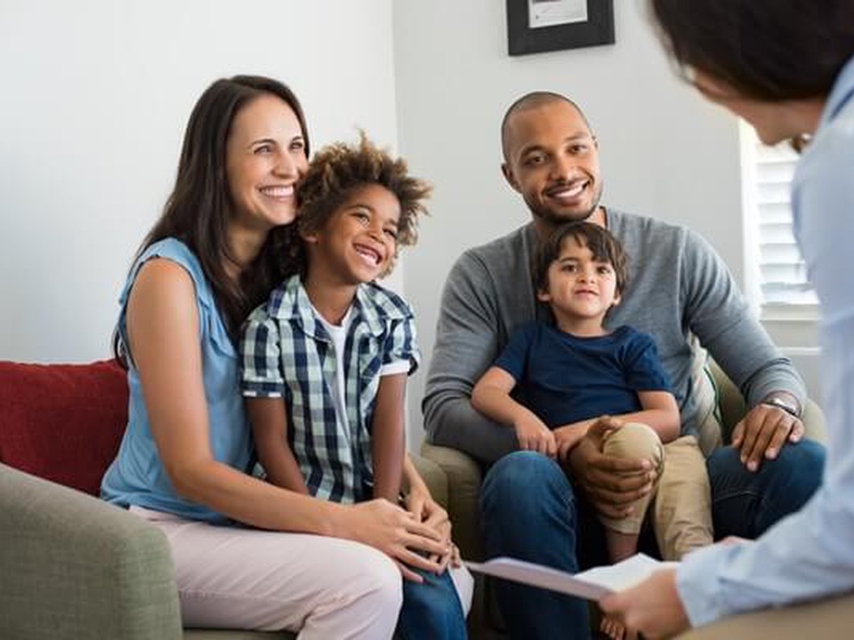A family with a woman, a man and two boys on a counselor consultation