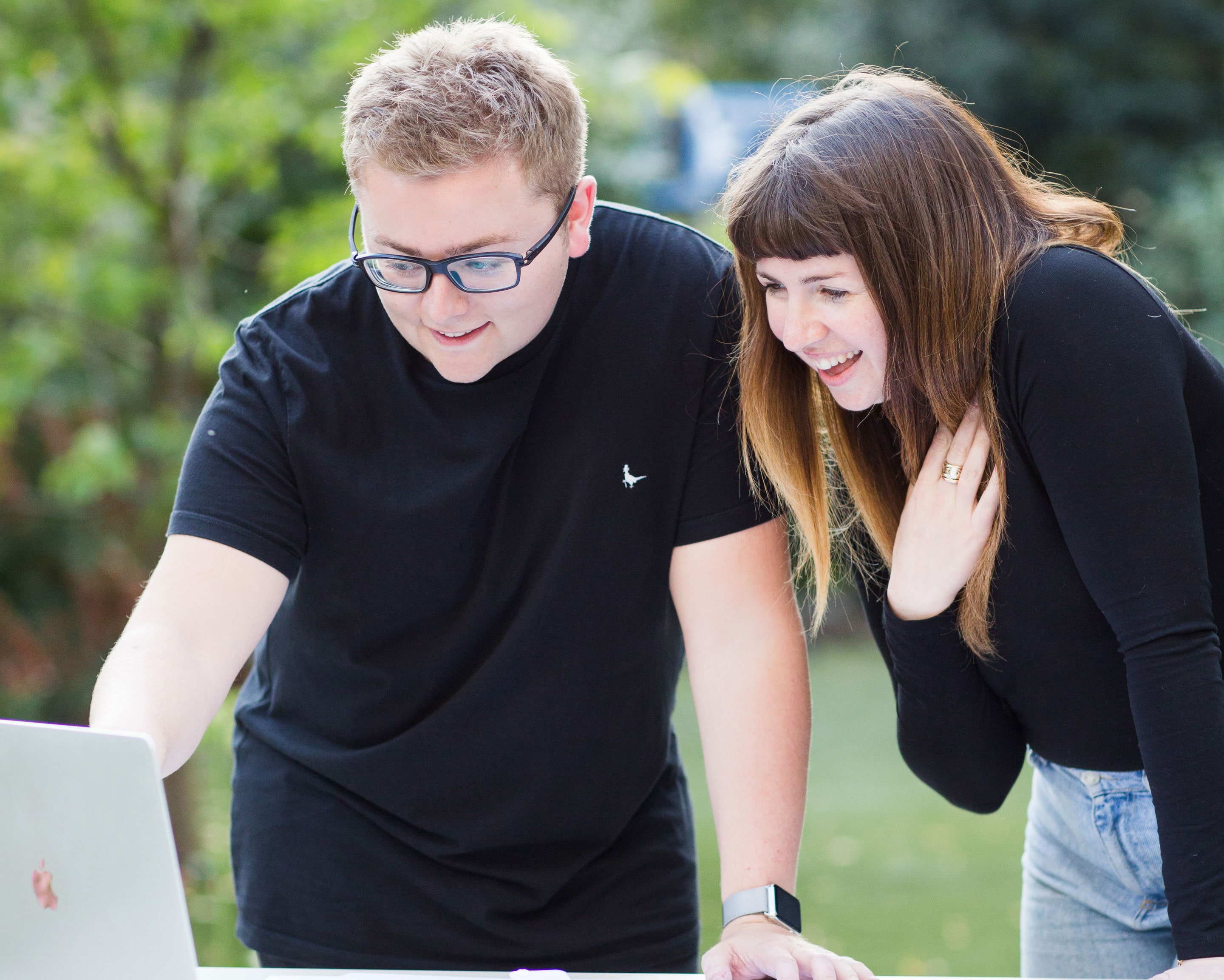 Jack Watkins in a black t-shirt presenting branding and website ideas to a client on a MacBook