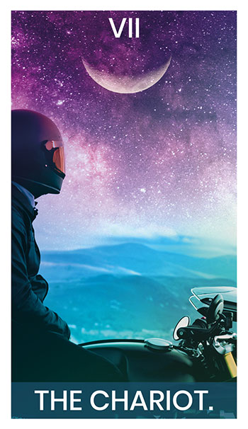 The Chariot card. A man on a motorcycle looks out into the distance where mountains and stars meet.