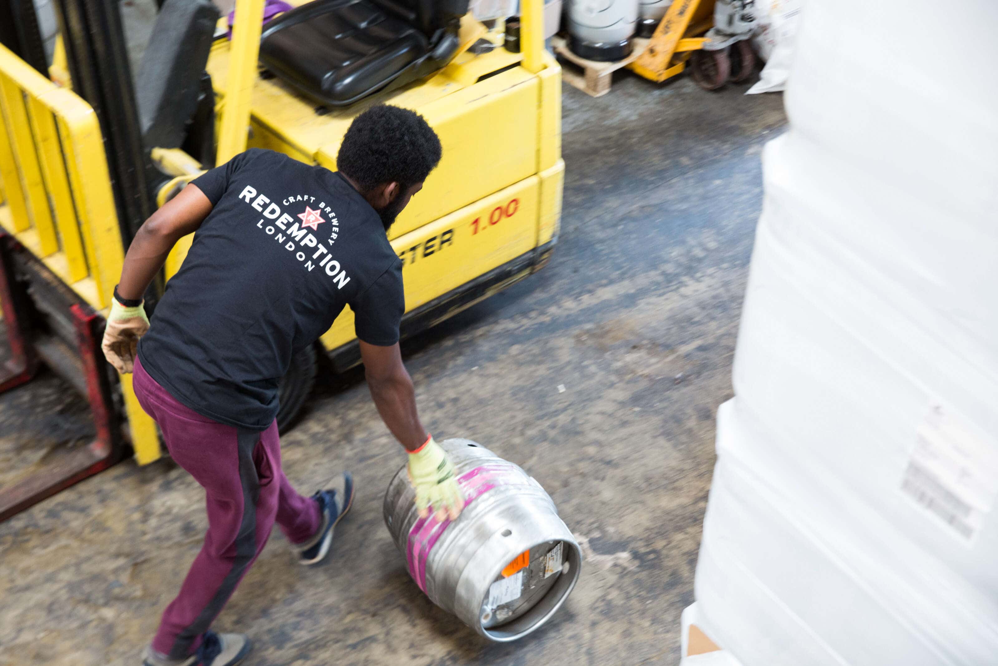 Person rolling a cask of beer