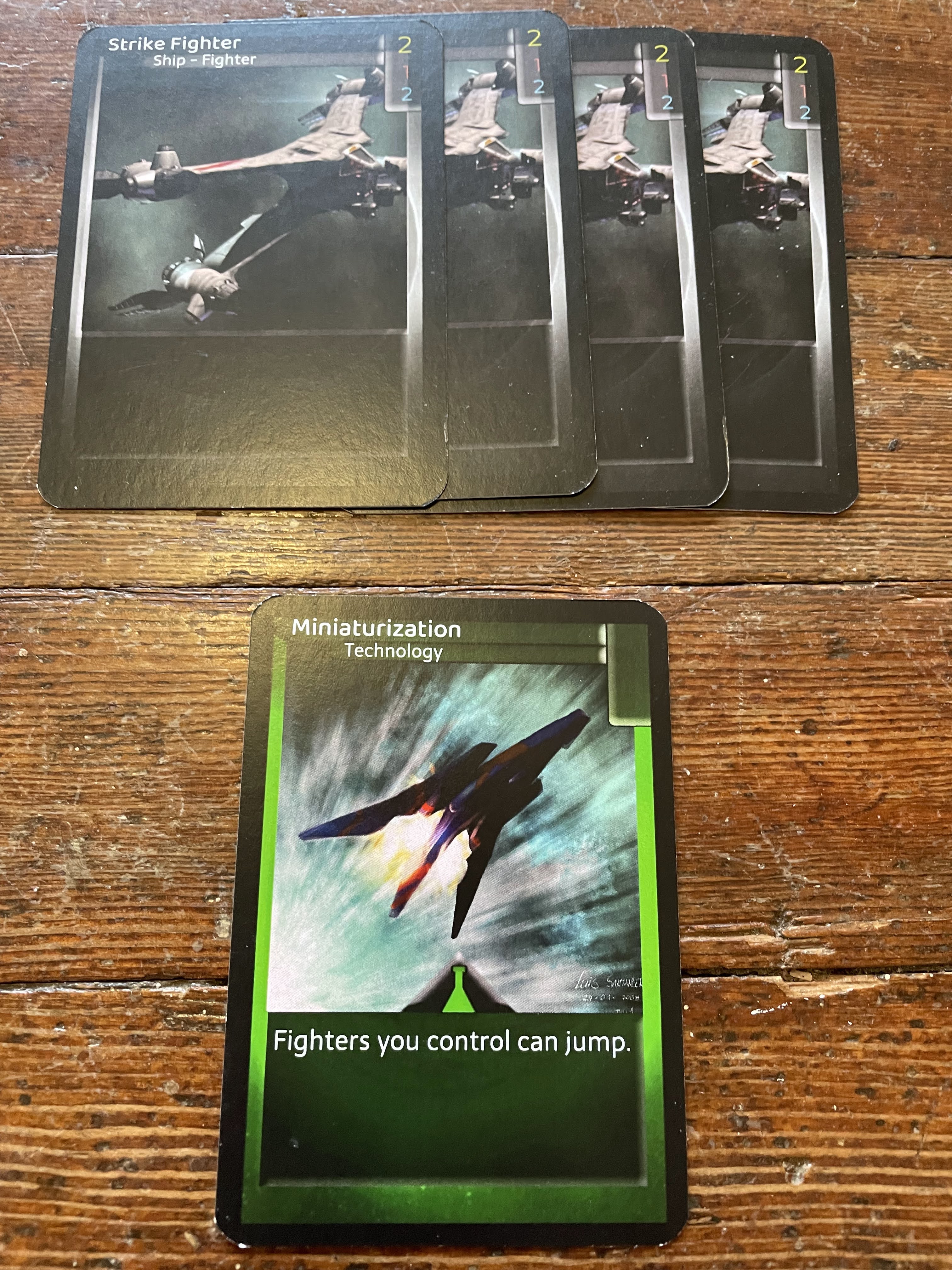 Miniaturization, a Science card, is placed beneath the four fighters.