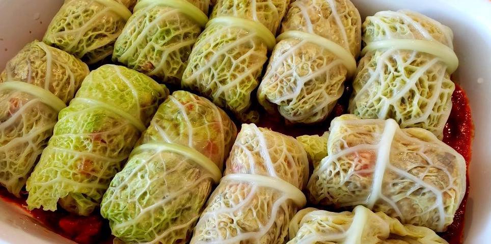 Uncooked cabbage rolls in casserole dish