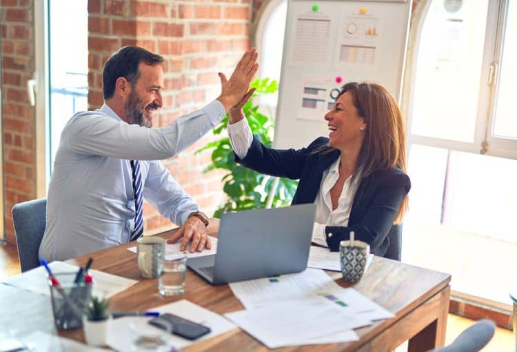 Power Automate Desktop Frau und Mann sitzen am Tisch mit Laptop
