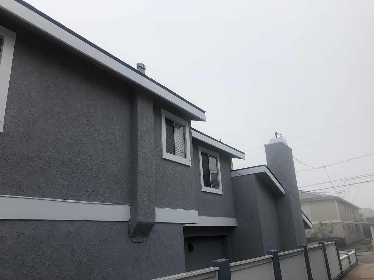 enlarged photo of second picture of a grey painted stucco home with white painted trim