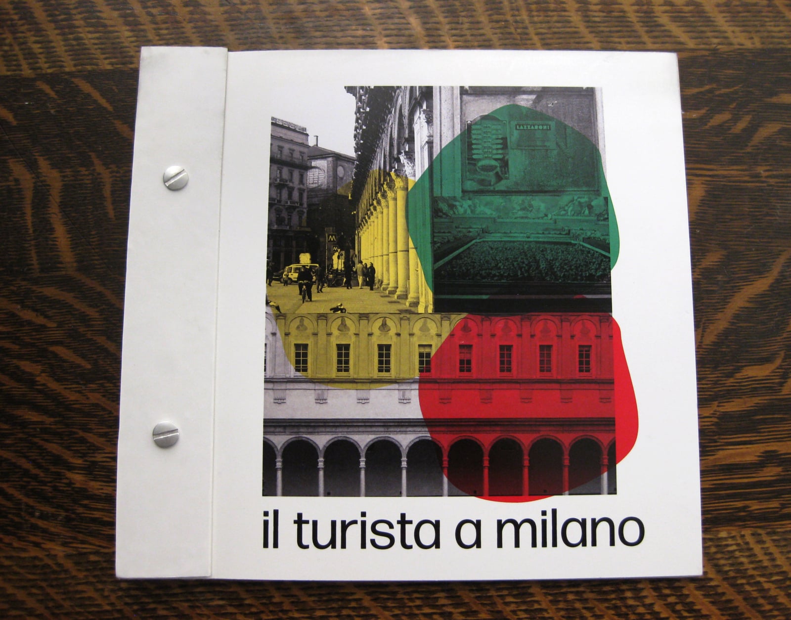 the front cover of a publication placed on a wooden desk. The title reads: Il Turista a Milano