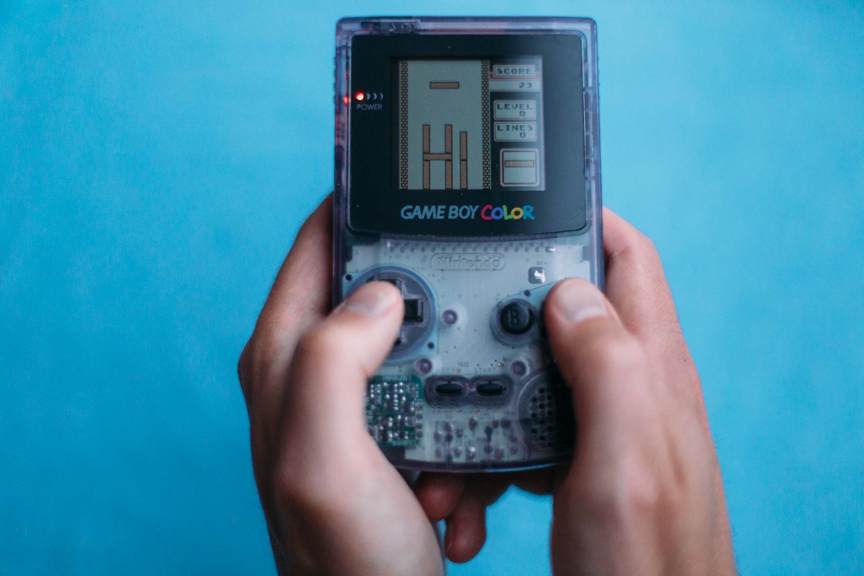 A game of Tetris on a Game Boy Color. It looks a bit weird! There's only one type of tetromino, the straight one. The pieces on the screen form the two-letter word hi.