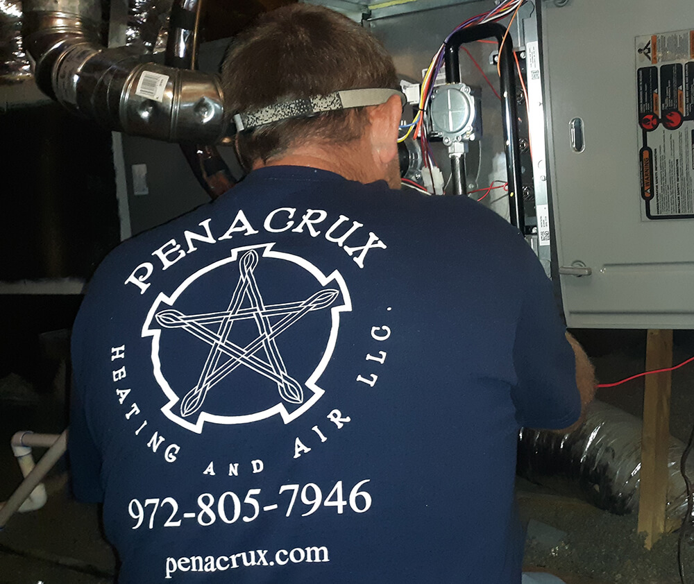Photo of a Penacrux repairman fixing an HVAC unit