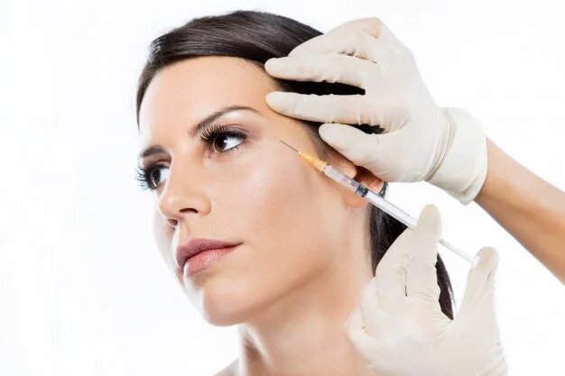 Woman receiving injection to side of face