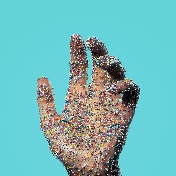 Hand with tiny multi-colored dots all over