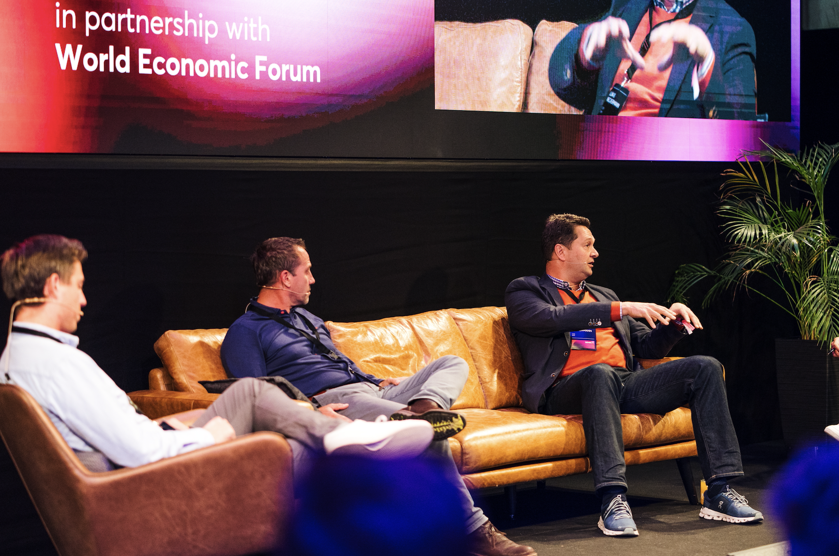 Three caucasian men sitting on a couch and discussing on the stage of Wunder Mobility Summit 2021.