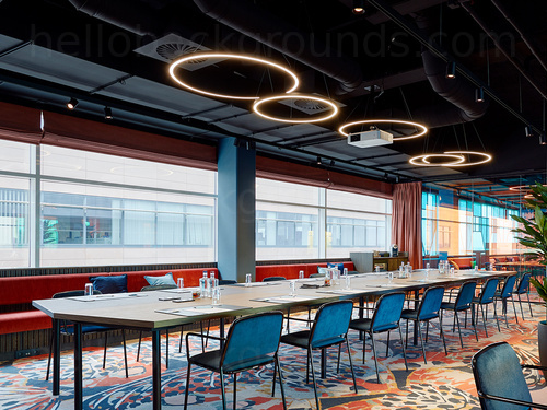 Artistically styled boardroom adorned with multiple pattern designs containing a long wooden table and large windows   Microsoft Teams background