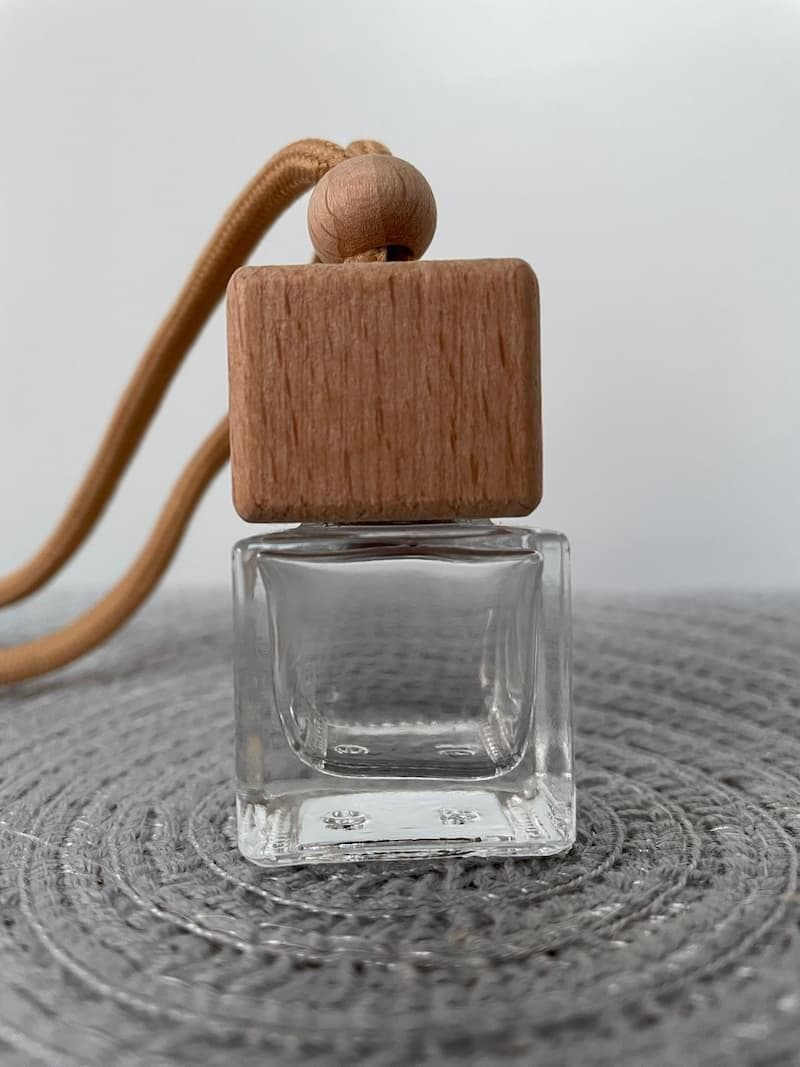 Glass bottle with wooden screw lid and string tie.