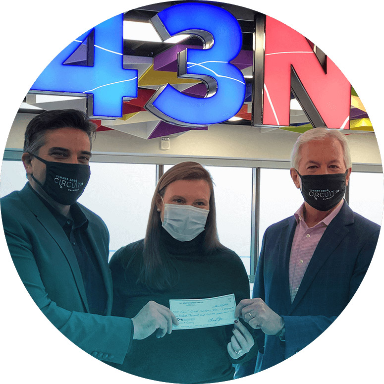 Three people holding a check