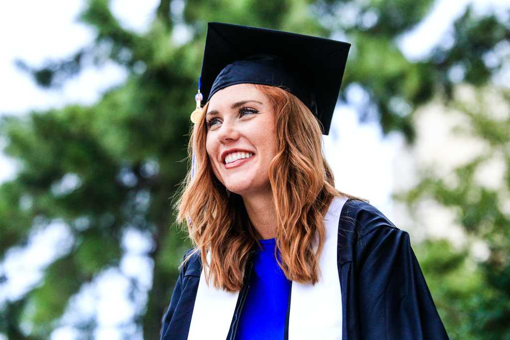 Young woman wearing cap and gown at graduation