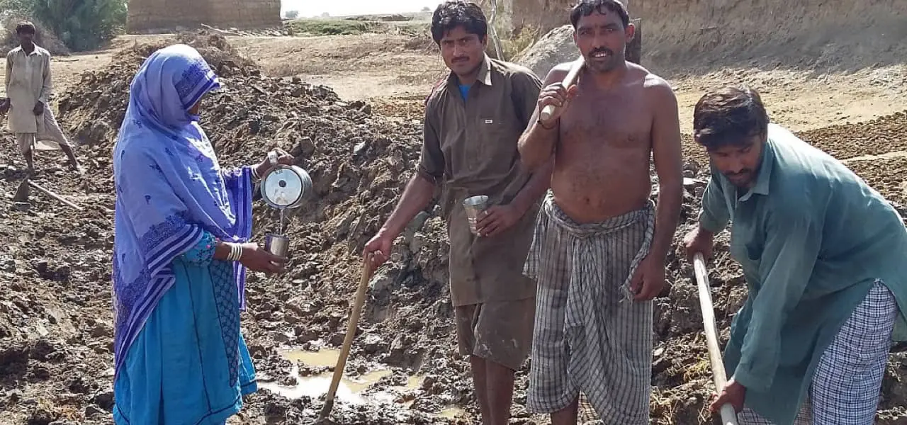 Men standing in front of a flood drain in Pakistan