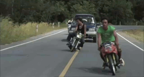 An animated gif of a scene from the movie 'Wonderful Town' showing a caravan of guys on motorcycles waeaving back and forth across the road lanes.