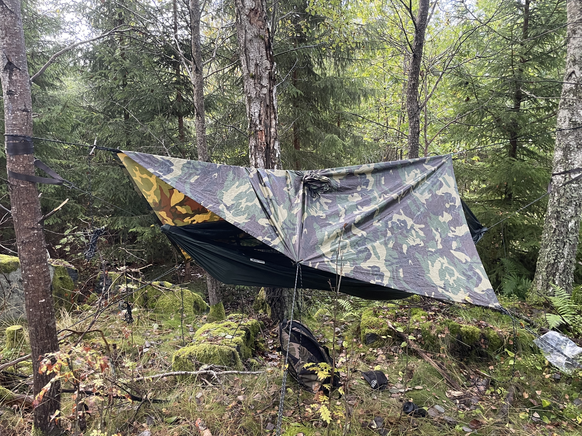 Wild camping with poncho-tarp, using the tarp to keep rain off but its slightly too short.