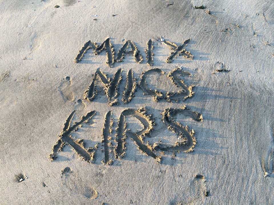 Maix, Nics, and Kirs written in the sand on the beach