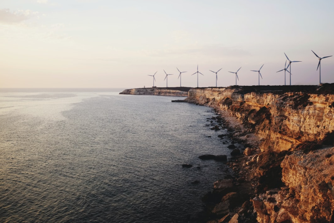 Windmills lined up on a rocky coast