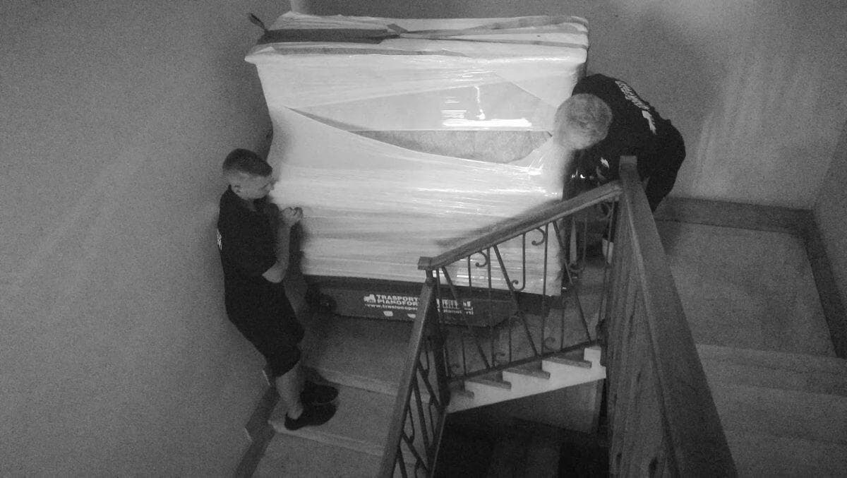 Persone che trasportano un pianoforte sulle scale con PianoPlan