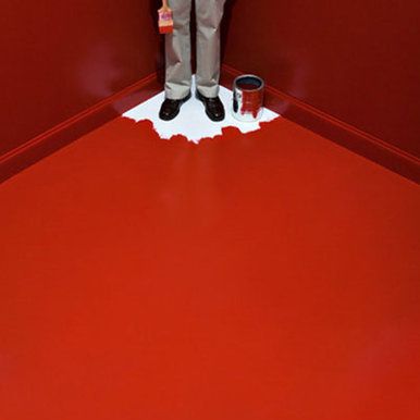 Person painting red room backed into a corner