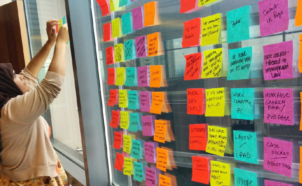 Image: Woman working with brightly colored sticky notes during project discovery phase
