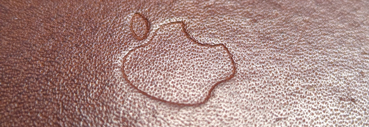 An Apple logo embossed into leather.