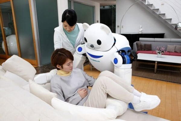 Friendly looking robot carries woman onto sofa