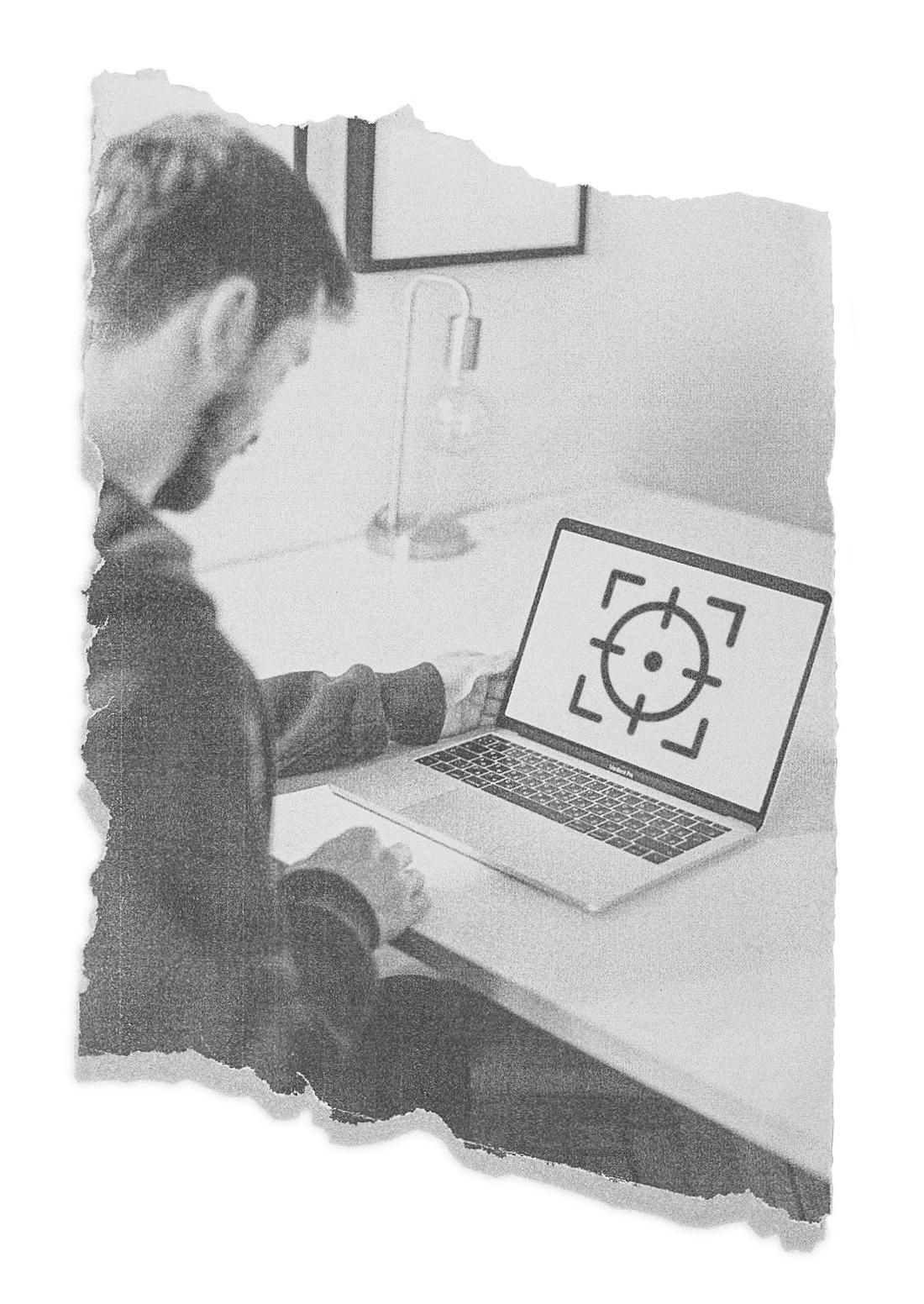 Ein Mann, der auf ein Fadenkreuz auf seinem Computerbildschirm blickt.