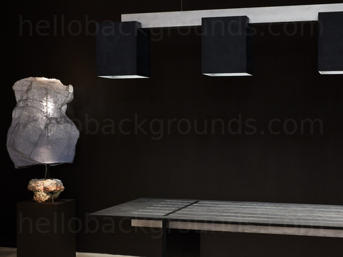 Grey table with square overhead lighting next to rock styled decorative lamp  Zoom background