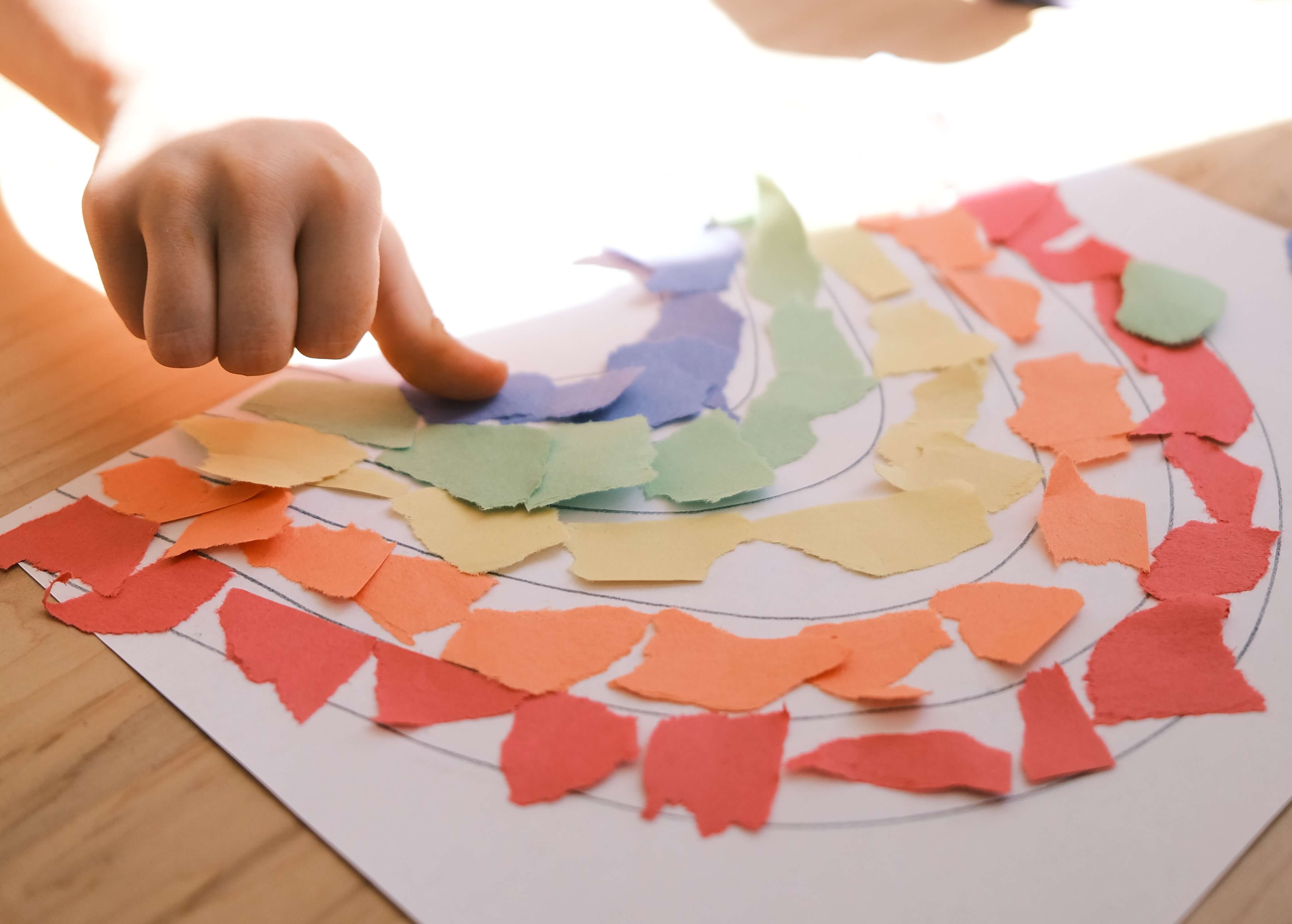 Child doing paper tearing and gluing work.