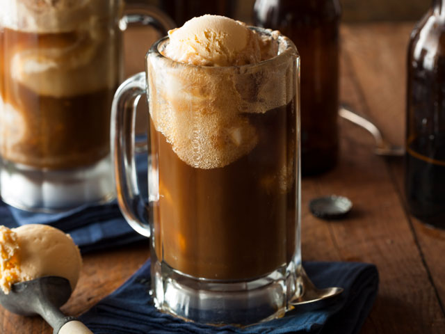 A Root Beer float made with vanilla ice cream in a glass mug