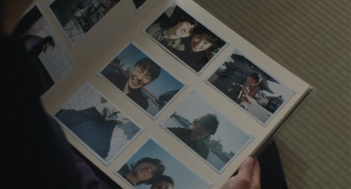 A screenshot from the film 'Maborosi' showing a couple's photo album.