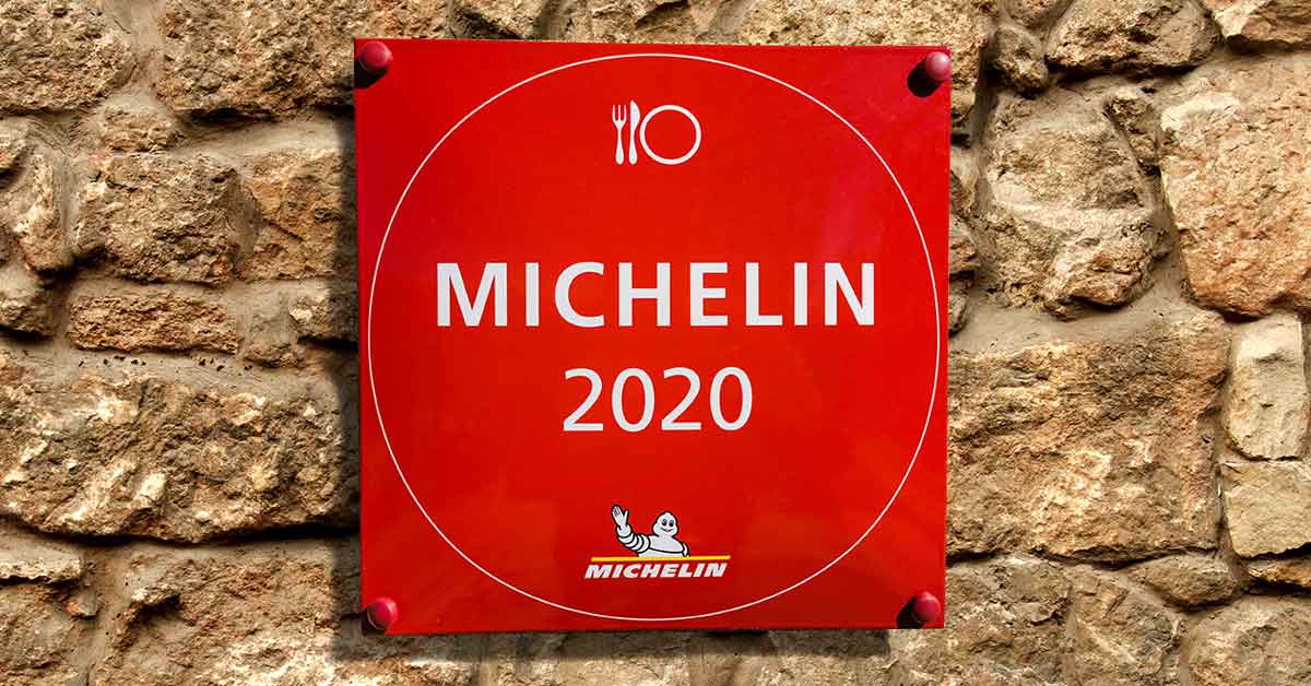 A red sign reading MICHELIN 2020 on a stone wall.