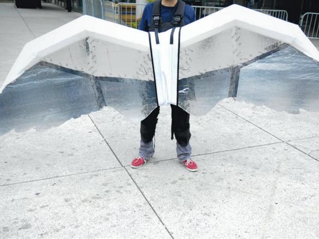 a man wears a flight suit made of white wings of about a 6 foot span, part of Jeremijenko's collaborative project with Usman Haque, to create personal flight paths as future transportation.